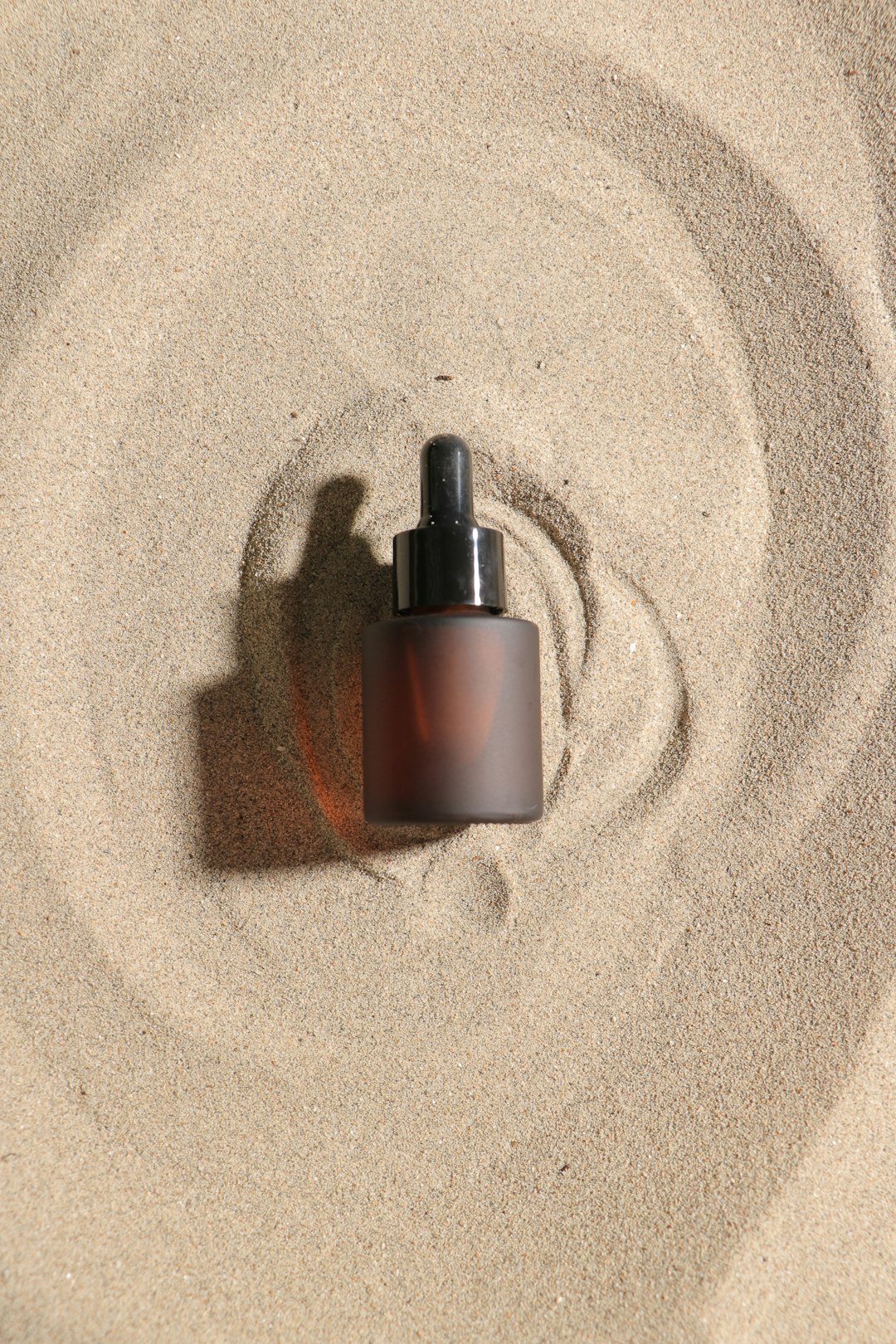 Glass dropper bottle with natural green skincare serum on clean minimal background
